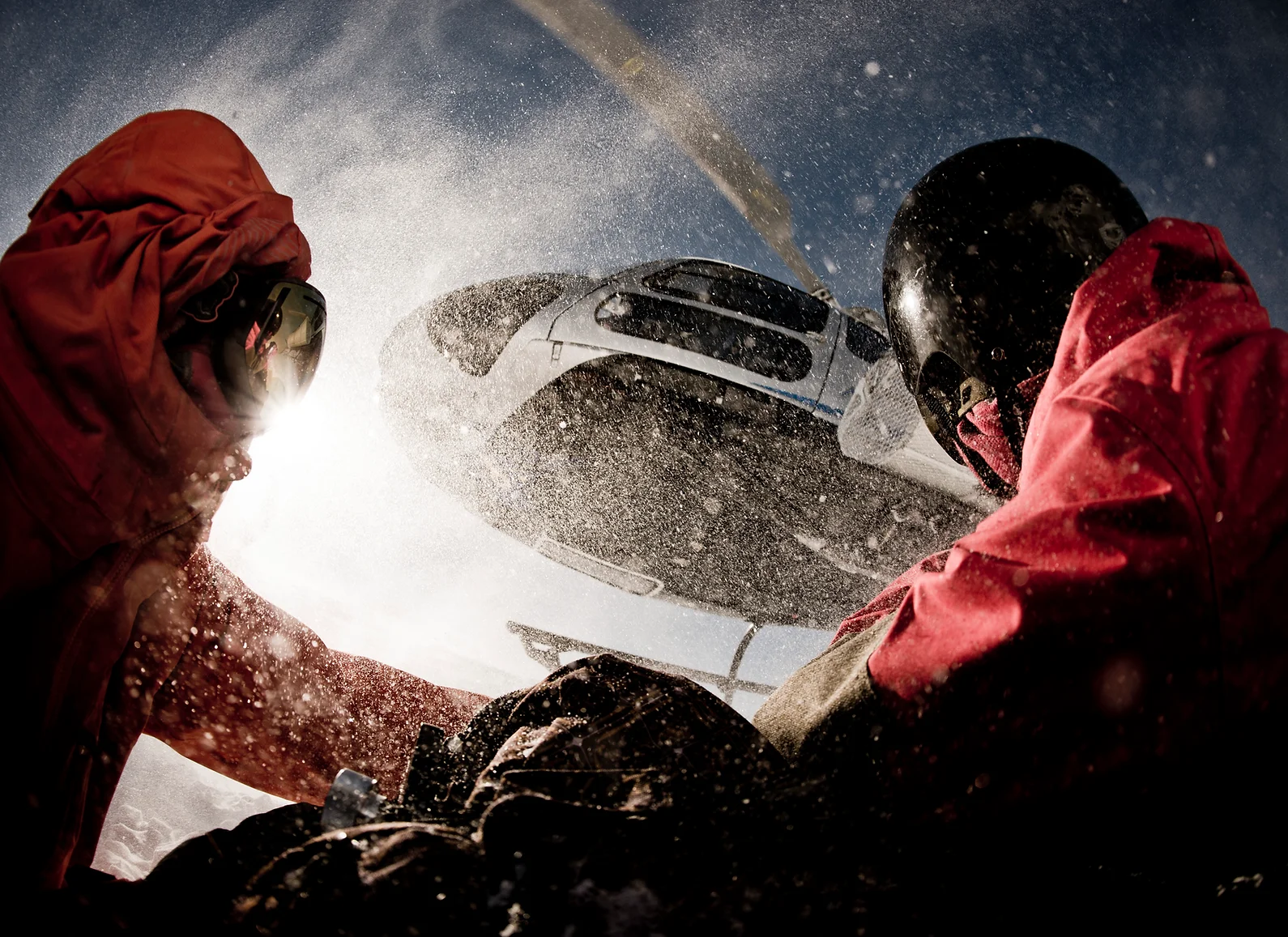 two people shaking hands in front of a helicopter